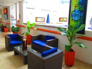 un vestíbulo con sillas y plantas en una tienda en Hotel Bucaros, en Espinal