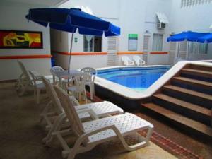 una piscina con sillas y sombrillas junto a una piscina en Hotel Bucaros, en Espinal