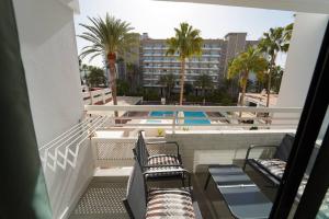 een balkon met 2 stoelen en een zwembad bij Tropical Views - Paya del Inglés in Maspalomas