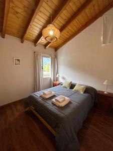 a bedroom with a large bed with towels on it at ALBANTA Lago Puelo in Lago Puelo