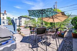 una mesa con sillas y una sombrilla en el patio en Historic Corner Apartment with patio & off street parking, en Portland