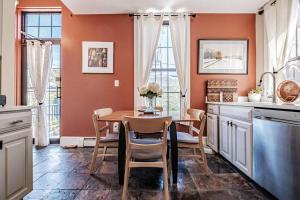 a kitchen with a table and chairs and a kitchen with orange walls at Historic Corner Apartment with patio & off street parking in Portland