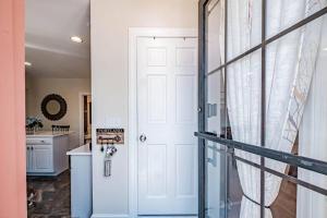 a hallway with a white door and a kitchen at Historic Corner Apartment with patio & off street parking in Portland +27 photos