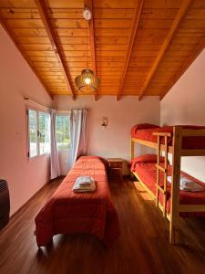 a bedroom with two bunk beds and a wooden ceiling at ALBANTA Lago Puelo in Lago Puelo