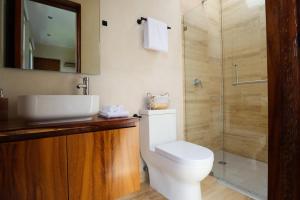 a bathroom with a toilet and a sink and a shower at Akbal Tulum in Tulum