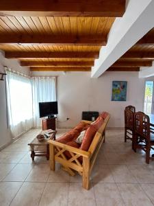 ein Wohnzimmer mit einem Sofa und einem TV in der Unterkunft ALBANTA Lago Puelo in Lago Puelo