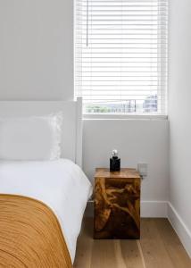 a white bedroom with a bed and a window at 5 Min to UT, Congress - Modern Home in DT East ATX in Austin
