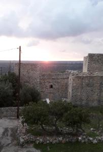 an old stone building with a sunset in the background at Πέτρινο σπίτι-Stone house in Koíta