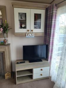 a entertainment center with a flat screen tv in a living room at Your Retreat Too in Camber