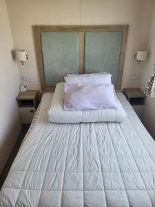 a large white bed in a bedroom with two night stands at Your Retreat Too in Camber