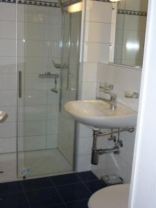ein Bad mit einem Waschbecken und einer Dusche in der Unterkunft Moderne attraktive Dachwohnung für max. 6 Personen in ruhiger Umgebung in Flims