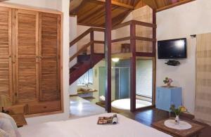 a living room with a staircase and a tv at Pousada Rio Dos Cristais in Visconde De Maua