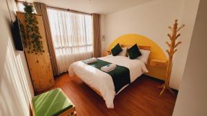 una camera con un grande letto con testiera in legno di Hotel Natural Sevgi a Bogotá
