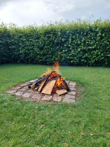 a fire pit in the grass in a yard at Luksus Shelter med vildmarksbad in Flemming