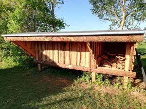 a wooden shed with a tin roof on top at Luksus Shelter med vildmarksbad in Flemming