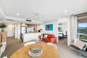 een woonkamer met een tafel en een bank bij Jamieson Apartments Reid ACT in Canberra