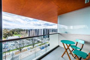 een balkon met een tafel en stoelen en uitzicht op de stad bij Jamieson Apartments Reid ACT in Canberra