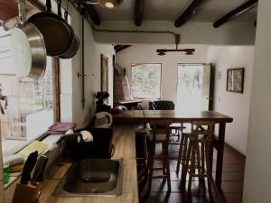 cocina con mesa, sillas y fregadero en Ataraxia - Atarixa, en Subachoque
