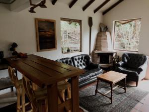 sala de estar con mesa y sofá en Ataraxia - Atarixa, en Subachoque