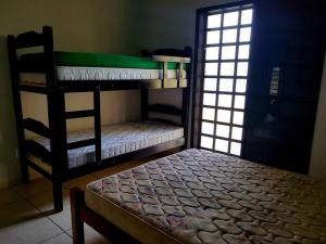 a bedroom with two bunk beds in a room at Casa para Temporada em Cananéia in Cananéia