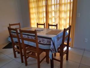 a dining room table with four chairs and a tablecloth on it at Casa para Temporada em Cananéia in Cananéia