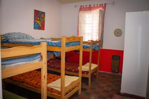 1 dormitorio con 3 literas en una habitación en El Viaje Hostel en Mina Clavero