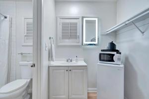 W białej łazience znajduje się umywalka i kuchenka mikrofalowa. w obiekcie Santa Monica Hotel w Los Angeles