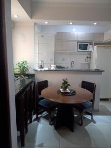 uma cozinha com mesa e cadeiras e uma cozinha com balcão em Apartamento de um quarto, próximo ao Estadual. em Bauru