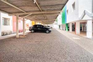 a black car parked under a covered parking lot at Apartamento de um quarto, próximo ao Estadual. in Bauru