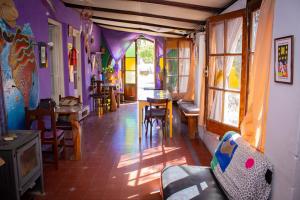 sala de estar con sofá, mesa y sillas en El Viaje Hostel en Mina Clavero