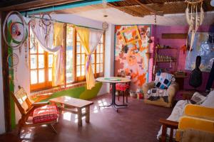 sala de estar con paredes coloridas, mesa y sillas en El Viaje Hostel en Mina Clavero