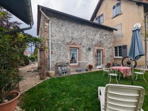 un patio trasero con mesa, sillas y sombrilla en Gîte Saulcy-sur-Meurthe, 3 pièces, 4 personnes - FR-1-589-256 en Saulcy-sur-Meurthe
