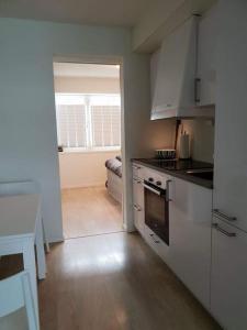 a kitchen with white cabinets and an open door at Book an apartment just for you in central Tromsø in Tromsø