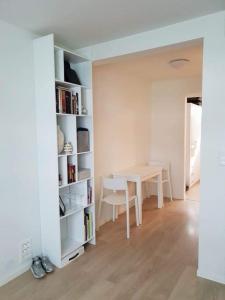 una camera bianca con tavolo, tavolo, scaffali e tavolo di Book an apartment just for you in central Tromsø a Tromsø