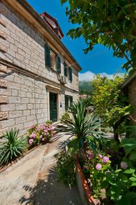 ein Steinhaus mit grüner Tür und Blumen in der Unterkunft Apartments by the sea Dubrovnik - 20309 in Dubrovnik