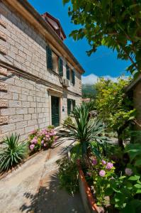 a stone house with a green door and flowers at Apartments by the sea Dubrovnik - 20309 in Dubrovnik