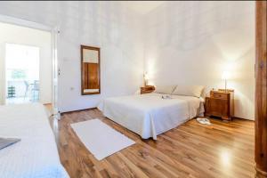 Apartments by the sea Dubrovnik - 20309 في دوبروفنيك: غرفة نوم بيضاء مع سرير ومرآة