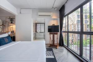 IR-ON Hotel في بانكوك: غرفة نوم بها سريران كبيران أبيضان ونوافذ كبيرة