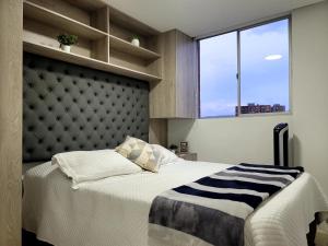 - une chambre avec un grand lit et une grande fenêtre dans l'établissement Modern 2/2 Apartment in Sabaneta with City View, à Sabaneta