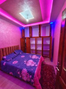 a bedroom with a bed with purple lights on it at Residence Anarouz - Sidi Ifni in Sidi Ifni