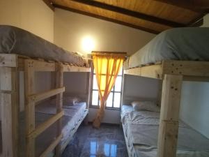 a bedroom with two bunk beds and a window at Villa Claudia in Villa de Leyva