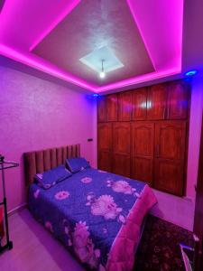 a bedroom with a bed with pink lights on it at Residence Anarouz - Sidi Ifni in Sidi Ifni