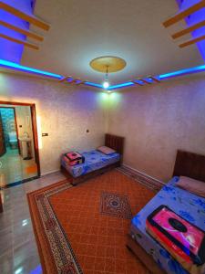 a room with two beds and a blue light at Residence Anarouz - Sidi Ifni in Sidi Ifni
