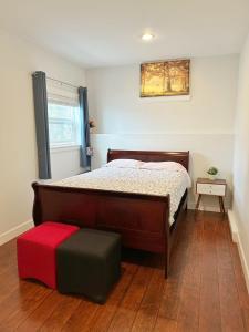 a bedroom with a large bed with a ottoman and a window at Oasis in Victoria