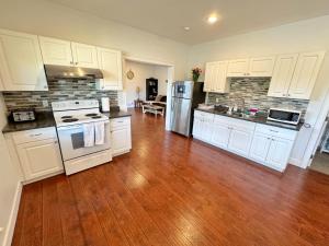 a kitchen with white cabinets and a hard wood floor at Oasis in Victoria