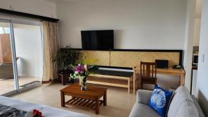 a living room with a couch and a tv on the wall at Resort Tava'e in Amuri