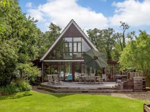 a house with a patio and an umbrella at Silver Waters in Wroxham