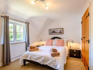 1 dormitorio con 1 cama con toallas en Hambury House en West Lulworth