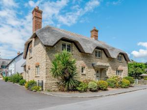 une grande maison en pierre avec un toit dans l'établissement Hambury House, à West Lulworth