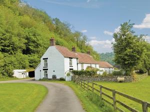 a white house with a fence next to a road at Ashberry Cottage in Rievaulx